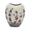 Flat and round purple vase cream background with lavender creeping up near to the rim attractive vase
