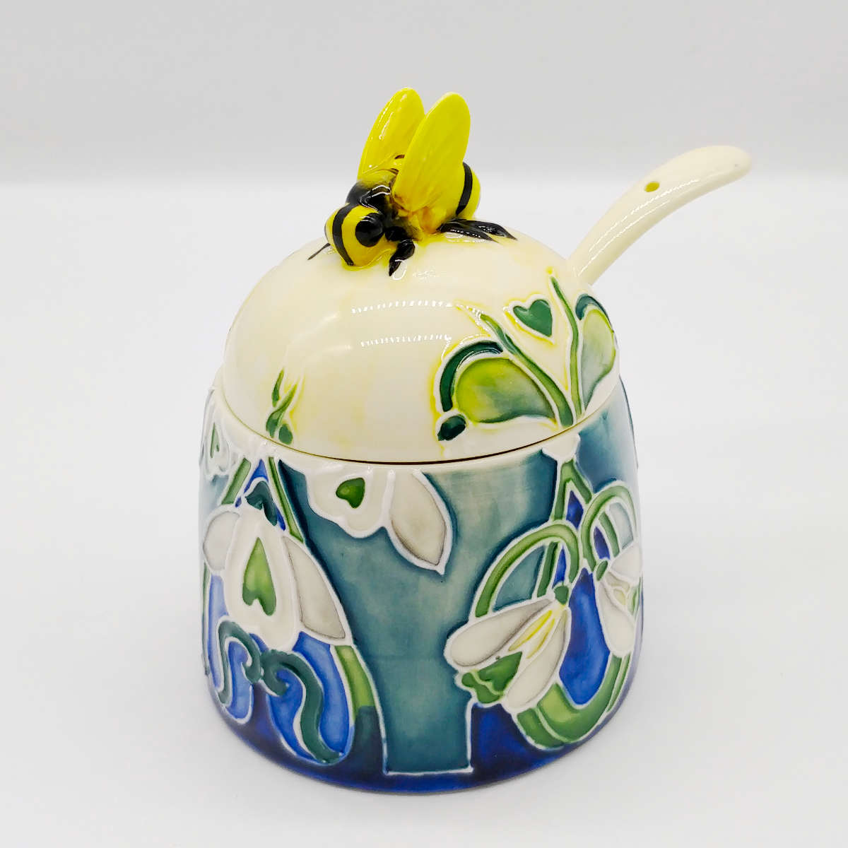 small round honey pot with lid and spoon made from ceramics white colour with blue green painted flowers